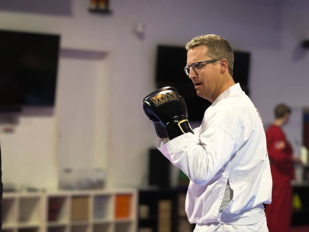 Jeon's World Martial Arts adult student in white gi with boxing gloves